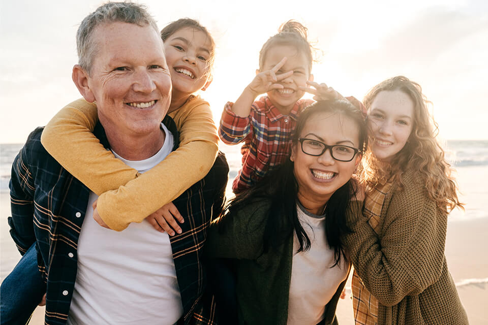 Image of a family smiling at the beach