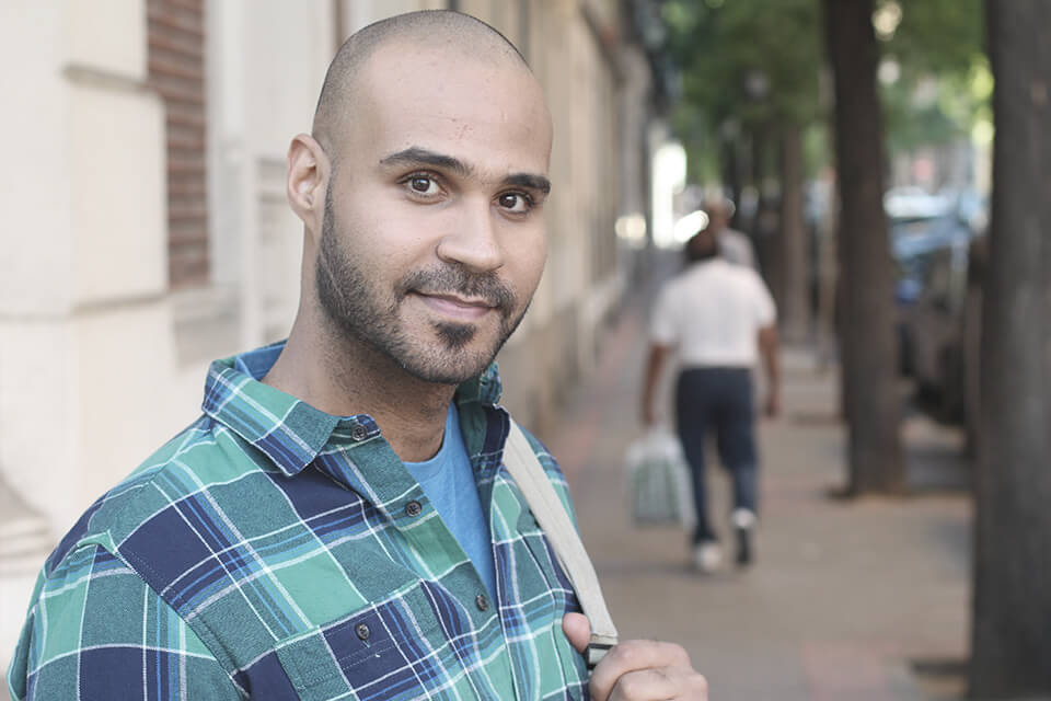 A man on a street looking into the camera