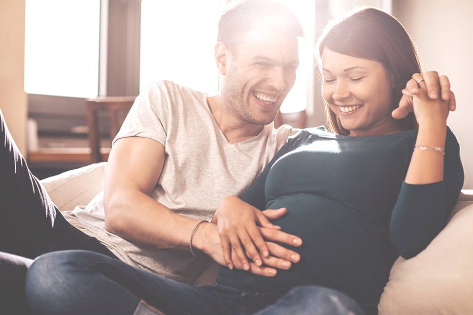 A pregnant lady and her partner looking to the future